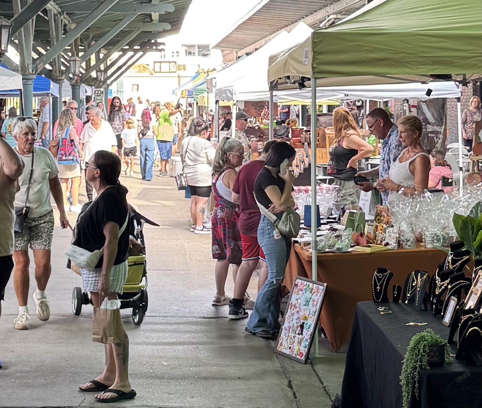 Shoppers browsing vendor booths along a packed market aisle at a Shop the Market At event